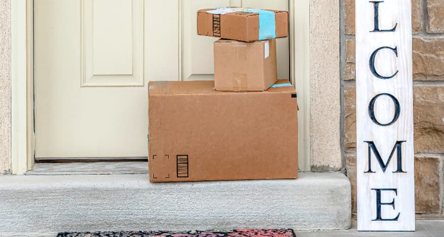 Packages on the doorstep of a home with a welcome sign in Evansville